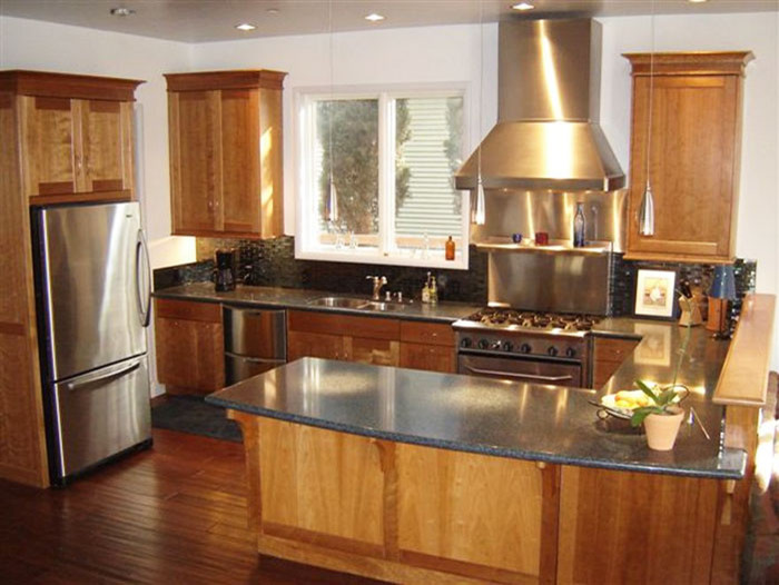 Klassisk inredning av ett mellanstort kök, med en dubbel diskho, luckor med infälld panel, skåp i mellenmörkt trä, bänkskiva i koppar, svart stänkskydd, stänkskydd i glaskakel, rostfria vitvaror och mellanmörkt trägolv