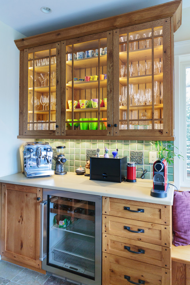 На фото: кухня в классическом стиле с стеклянными фасадами, фасадами цвета дерева среднего тона и зеленым фартуком