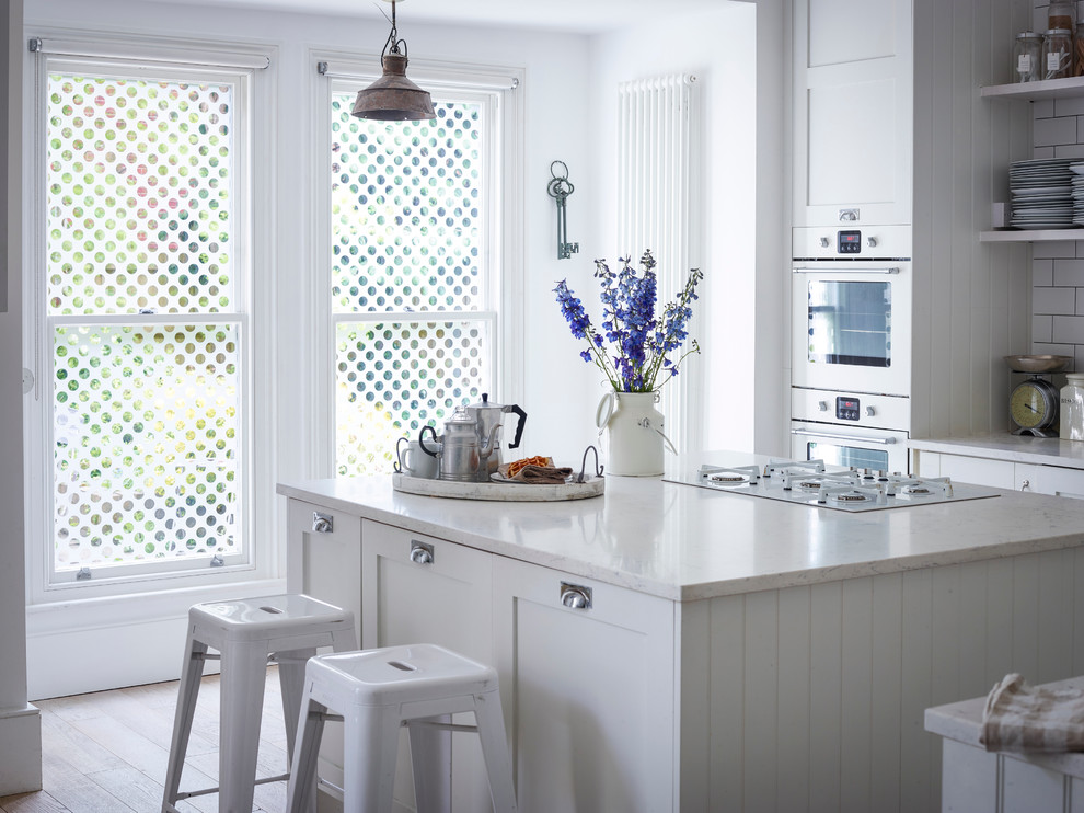 Inspiration for a transitional kitchen remodel in Buckinghamshire with white backsplash, subway tile backsplash and white appliances