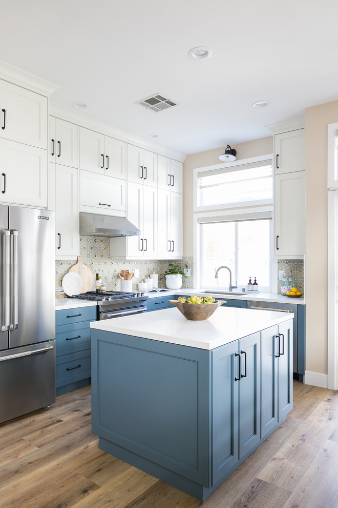 Transitional u-shaped medium tone wood floor kitchen photo in San Diego with beaded inset cabinets, white cabinets, quartz countertops, multicolored backsplash, porcelain backsplash, stainless steel appliances, an island and white countertops