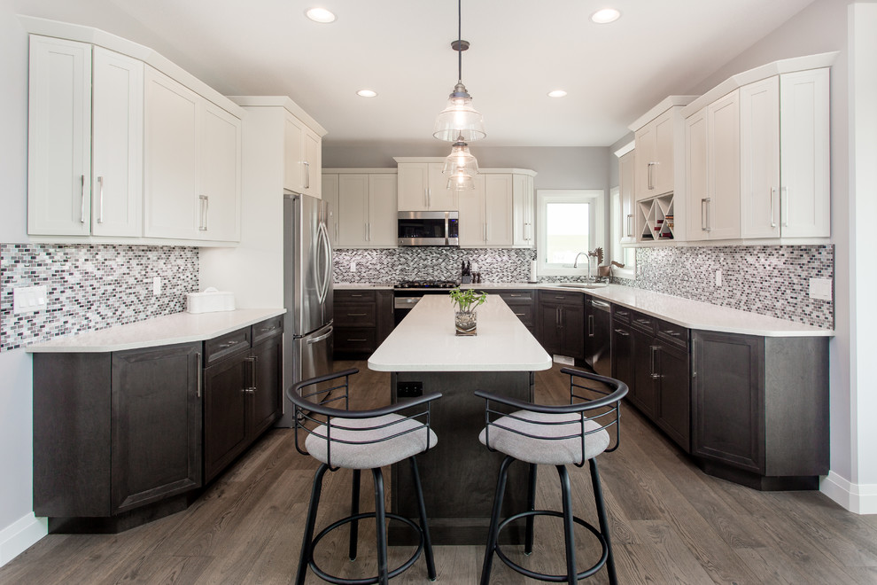Inspiration for a mid-sized craftsman u-shaped medium tone wood floor eat-in kitchen remodel in Calgary with an undermount sink, recessed-panel cabinets, white cabinets, quartz countertops, multicolored backsplash, glass sheet backsplash, stainless steel appliances and an island