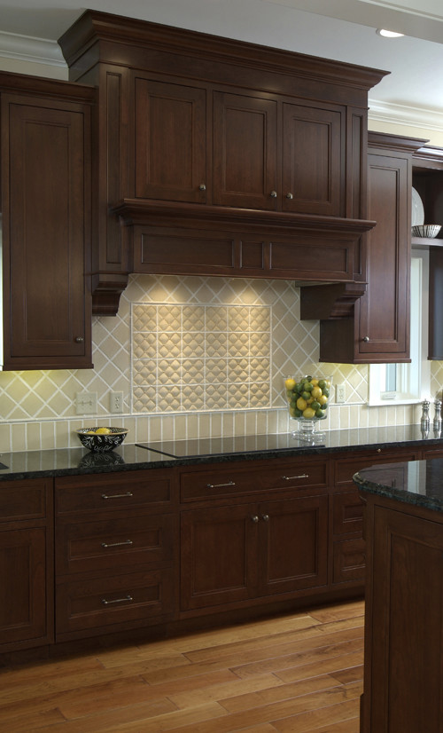 Example of a large transitional l-shaped medium tone wood floor open concept kitchen design in Grand Rapids with an undermount sink, recessed-panel cabinets, dark wood cabinets, granite countertops, ceramic backsplash, stainless steel appliances and an island