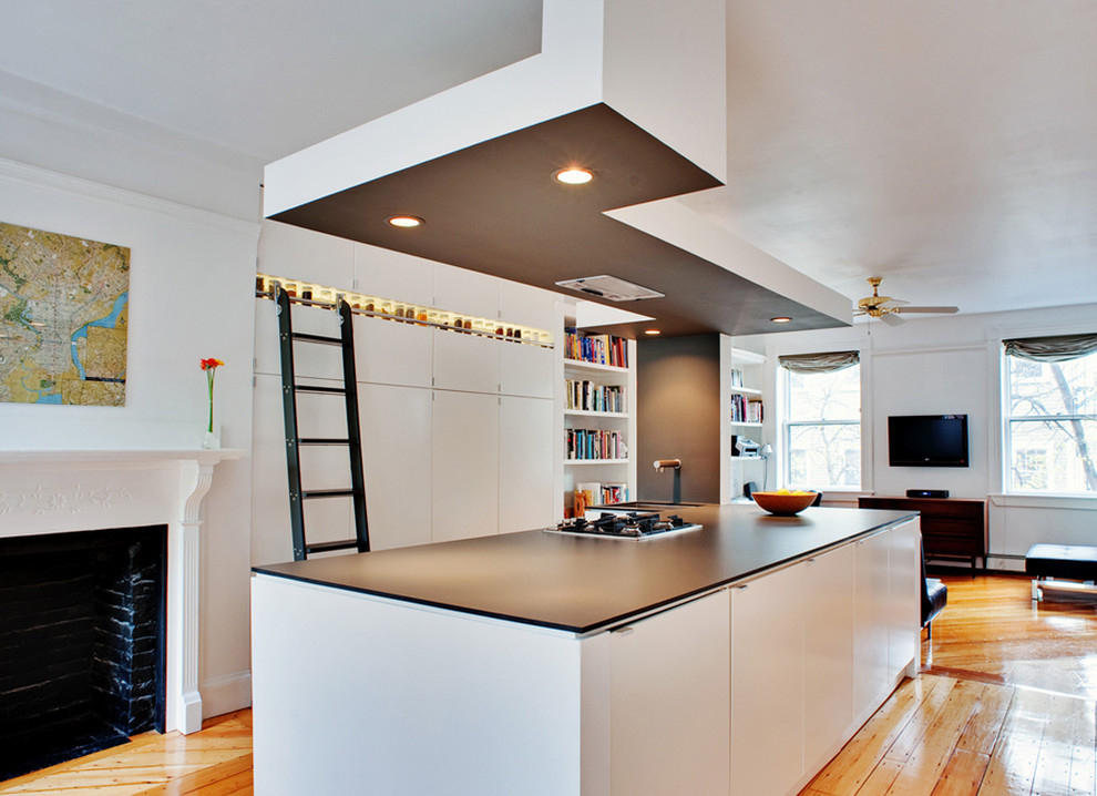 Foto på ett funkis kök med öppen planlösning, med en undermonterad diskho, släta luckor, vita skåp, bänkskiva i koppar, grått stänkskydd och rostfria vitvaror