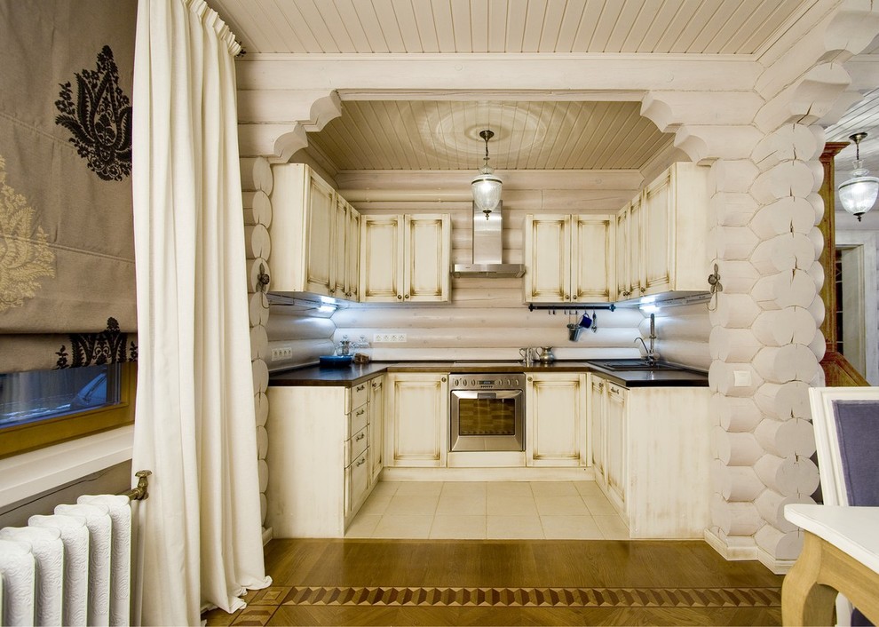 Cette image montre une cuisine ouverte rustique en U et bois vieilli avec un électroménager en acier inoxydable et aucun îlot.