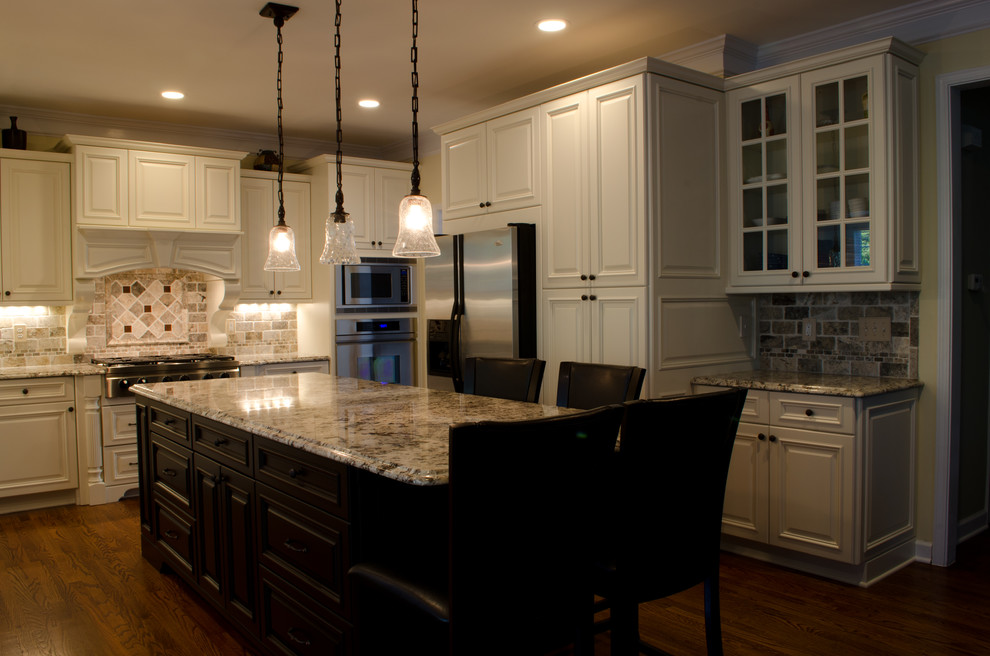 Kitchen - mid-sized traditional l-shaped dark wood floor kitchen idea in Raleigh with raised-panel cabinets, white cabinets, granite countertops, multicolored backsplash, ceramic backsplash, stainless steel appliances and an island