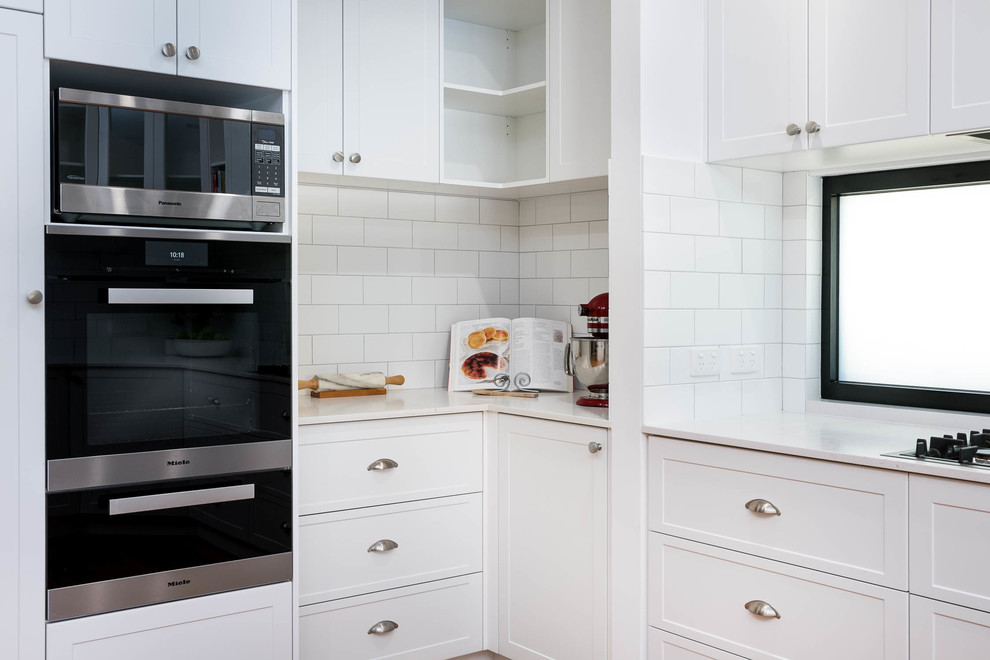Foto di una cucina minimal con top in marmo, paraspruzzi bianco, paraspruzzi con piastrelle diamantate e parquet chiaro