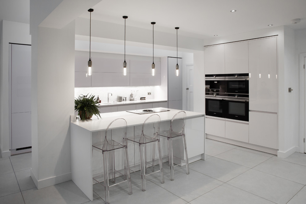 This is an example of a large contemporary l-shaped open plan kitchen in Essex with a submerged sink, glass-front cabinets, white cabinets, quartz worktops, multi-coloured splashback, marble splashback, integrated appliances, porcelain flooring, an island and white floors.