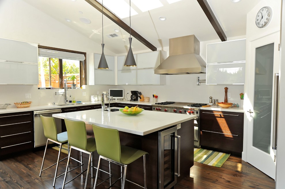 Large trendy l-shaped dark wood floor eat-in kitchen photo in San Francisco with glass-front cabinets, dark wood cabinets, stainless steel appliances, a farmhouse sink, solid surface countertops, white backsplash, stone slab backsplash and an island