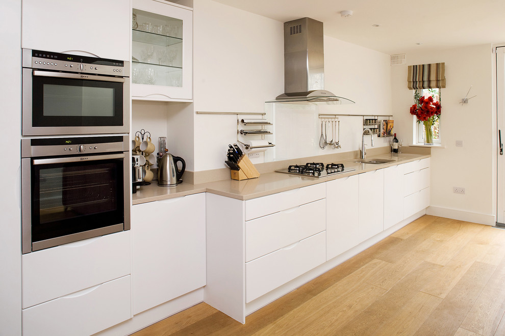 This is an example of a contemporary single-wall kitchen in Dublin with flat-panel cabinets and stainless steel appliances.
