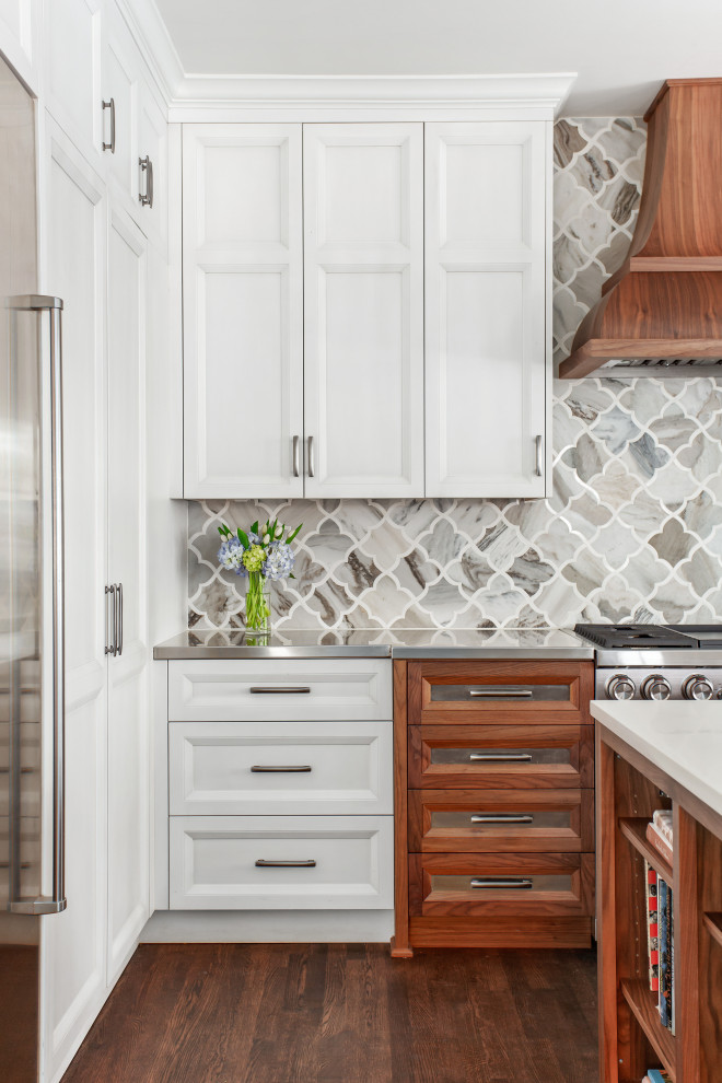 Idéer för att renovera ett stort amerikanskt grå grått kök, med en undermonterad diskho, luckor med infälld panel, vita skåp, bänkskiva i rostfritt stål, flerfärgad stänkskydd, stänkskydd i marmor, rostfria vitvaror, mörkt trägolv, en köksö och brunt golv