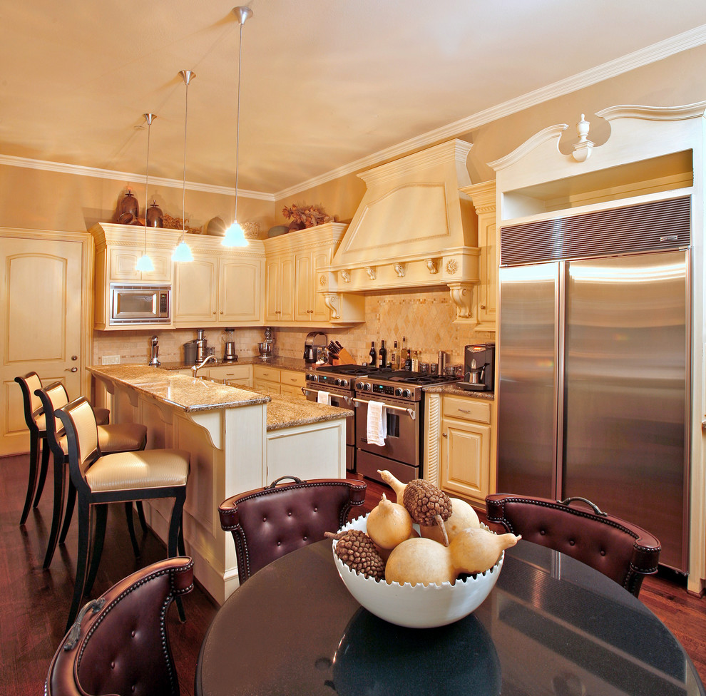 Eat-in kitchen - traditional l-shaped eat-in kitchen idea in Dallas with raised-panel cabinets, beige cabinets and stainless steel appliances