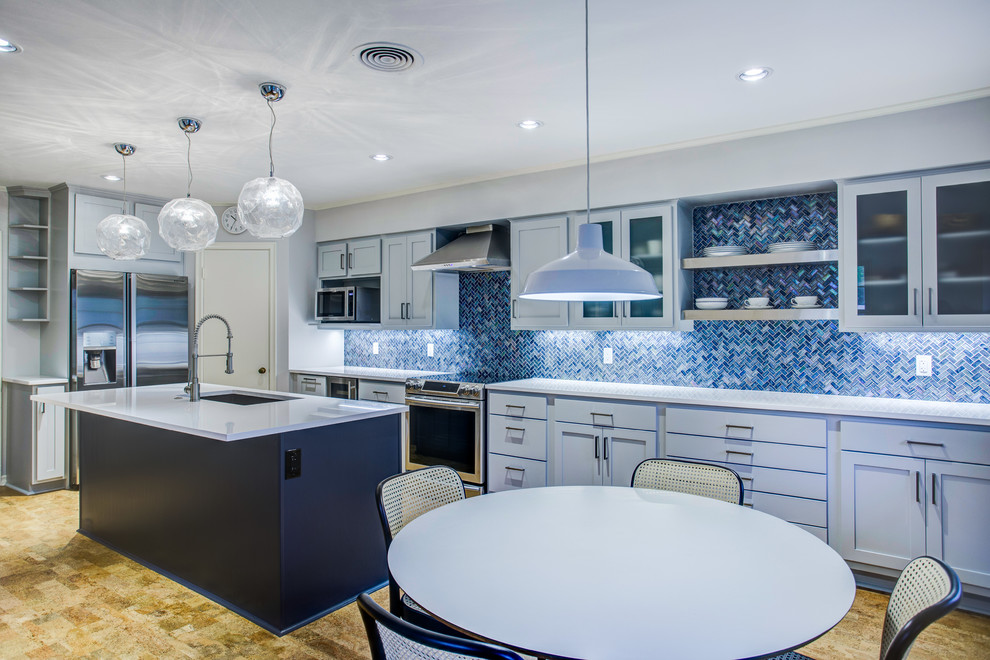 Foto på ett stort funkis vit kök, med en undermonterad diskho, skåp i shakerstil, blå skåp, bänkskiva i kvarts, blått stänkskydd, stänkskydd i mosaik, rostfria vitvaror, korkgolv, en köksö och brunt golv