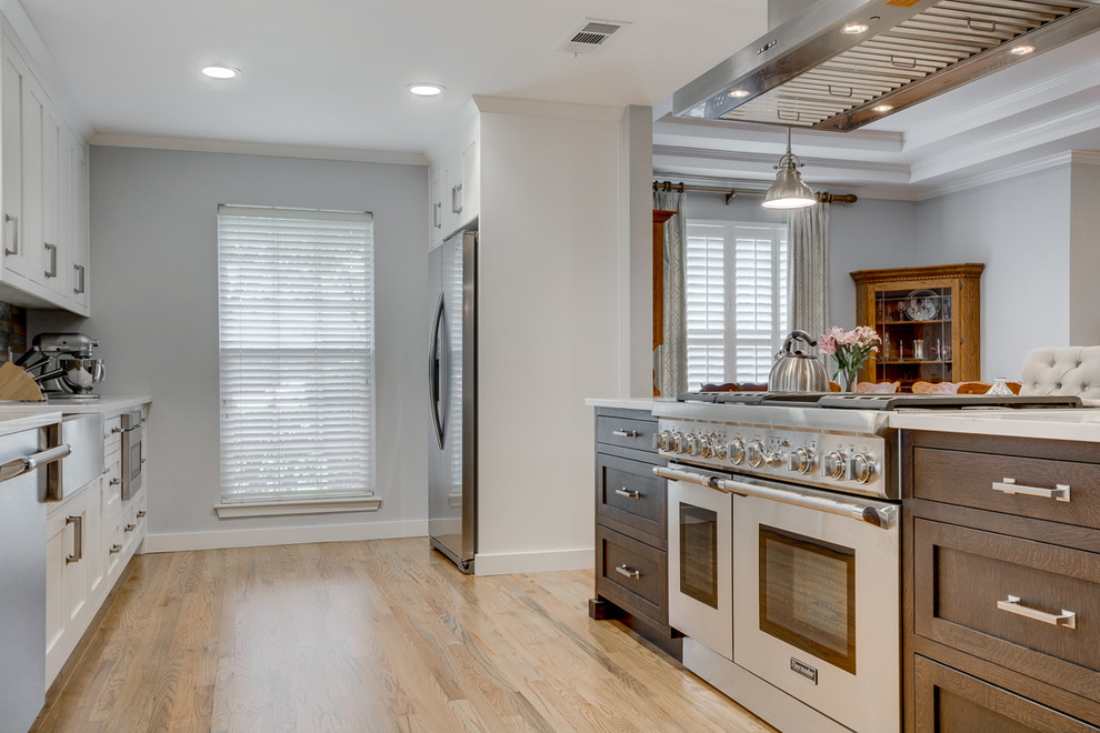 Large contemporary single-wall kitchen/diner in Dallas with white cabinets, granite worktops, brown splashback, stainless steel appliances, an island, a belfast sink, shaker cabinets and light hardwood flooring.
