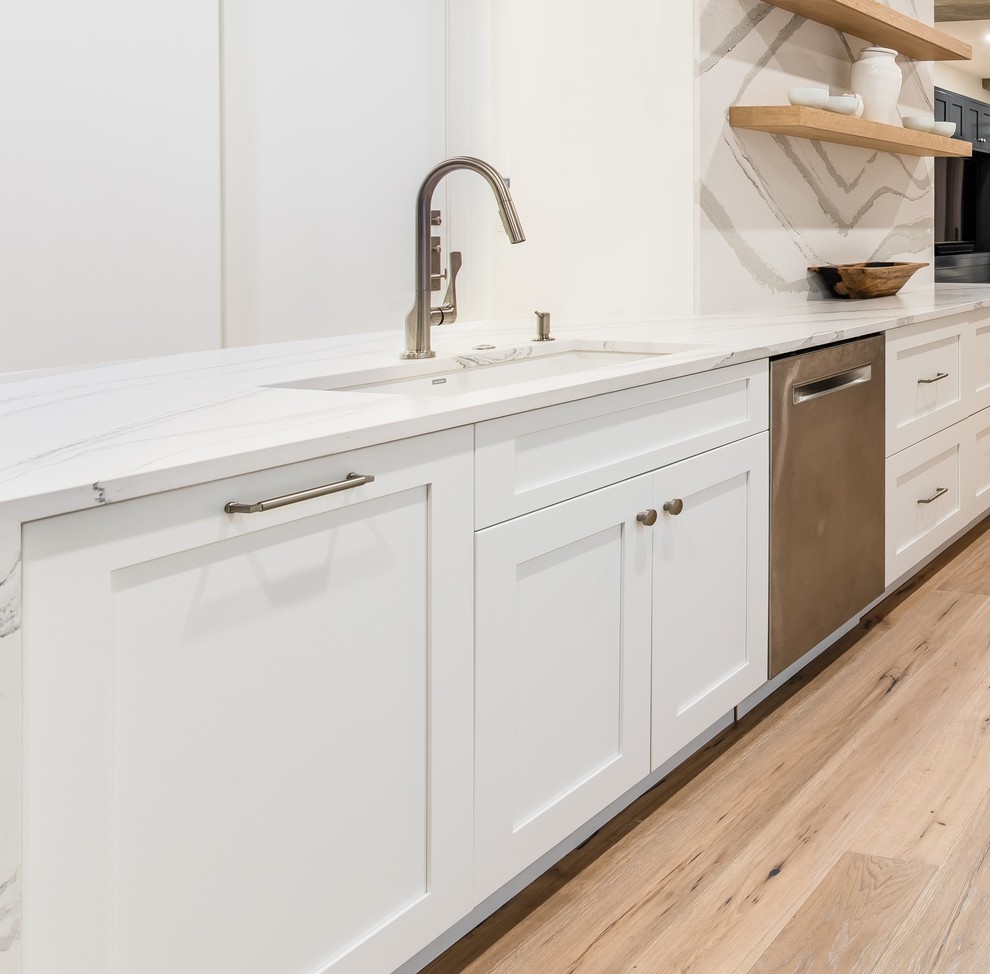 This is an example of a traditional kitchen in Dallas with engineered stone countertops, white splashback and white worktops.