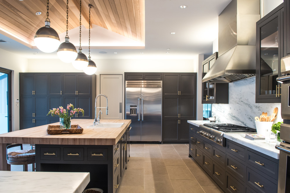 Large transitional l-shaped limestone floor and beige floor eat-in kitchen photo in Dallas with a drop-in sink, stainless steel appliances, an island, gray cabinets, marble countertops, white backsplash, stone slab backsplash and shaker cabinets