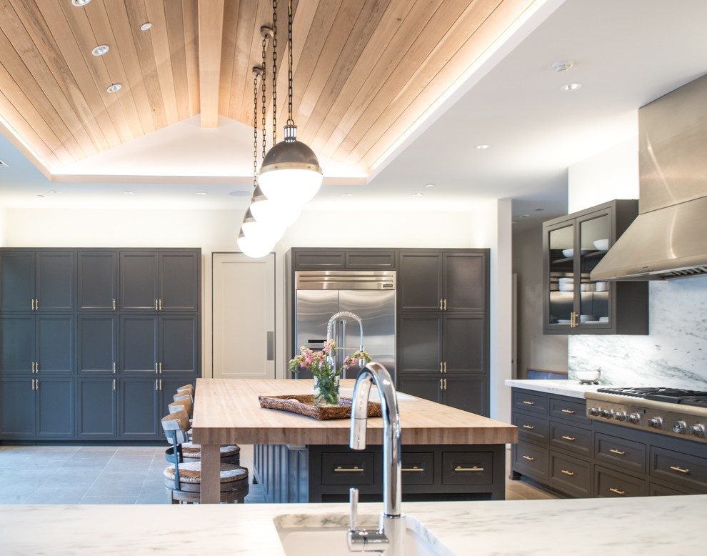 Inspiration for a large classic l-shaped kitchen/diner in Dallas with a built-in sink, beaded cabinets, grey cabinets, marble worktops, white splashback, stone slab splashback, stainless steel appliances, limestone flooring, an island and beige floors.