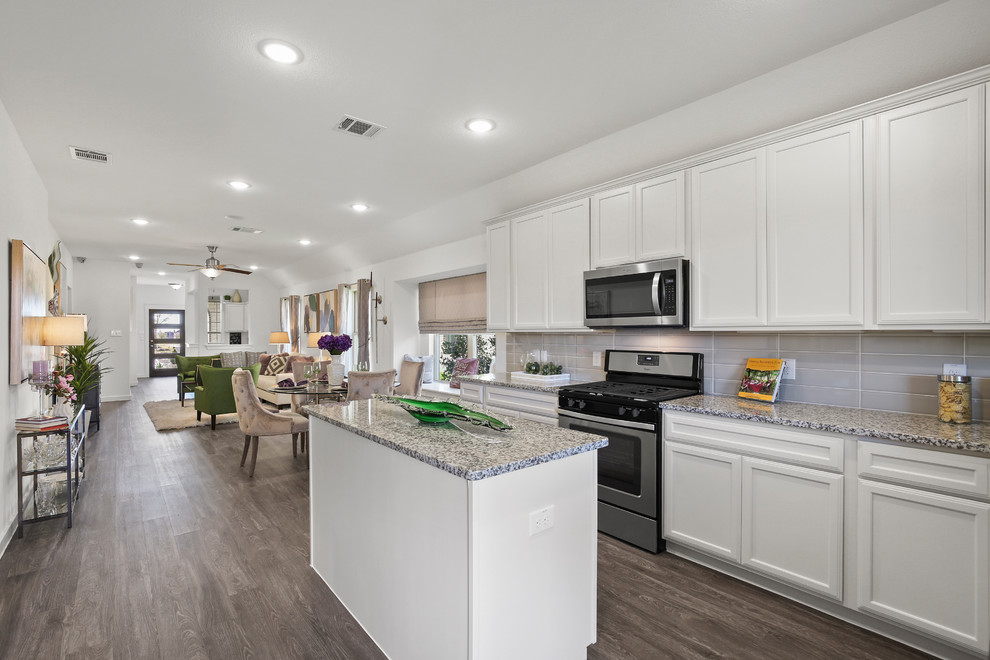 Mid-sized elegant l-shaped gray floor and medium tone wood floor eat-in kitchen photo in Dallas with an undermount sink, shaker cabinets, white cabinets, granite countertops, gray backsplash, ceramic backsplash, stainless steel appliances, an island and multicolored countertops