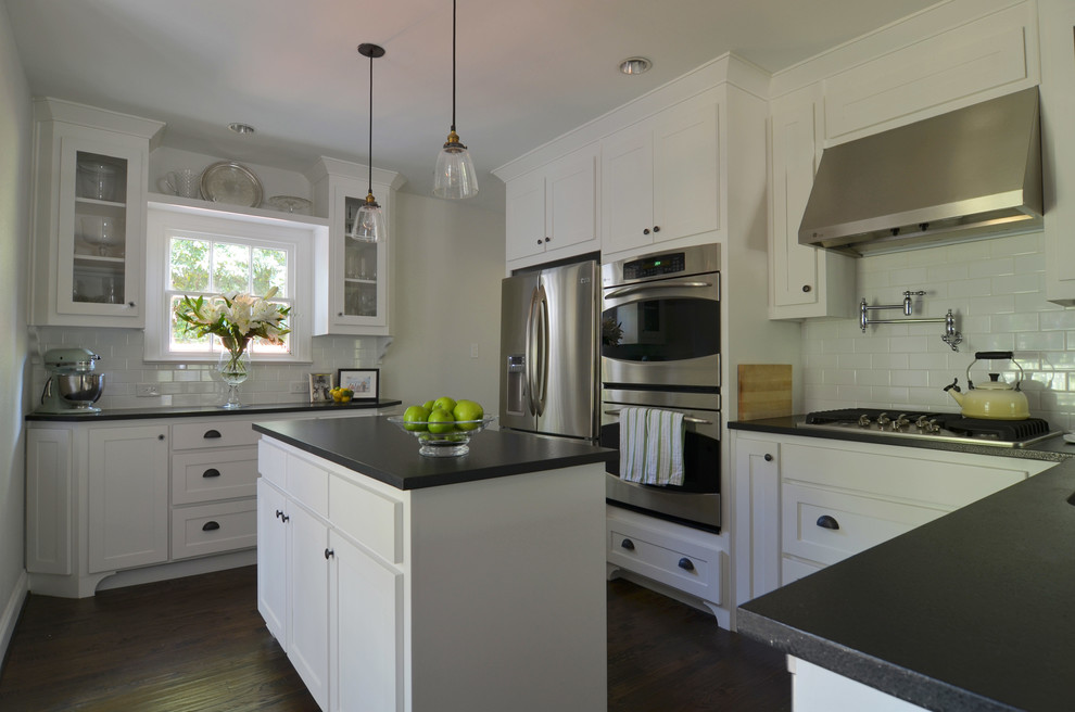 This is an example of a classic kitchen in Dallas with recessed-panel cabinets, white cabinets, white splashback, metro tiled splashback and stainless steel appliances.