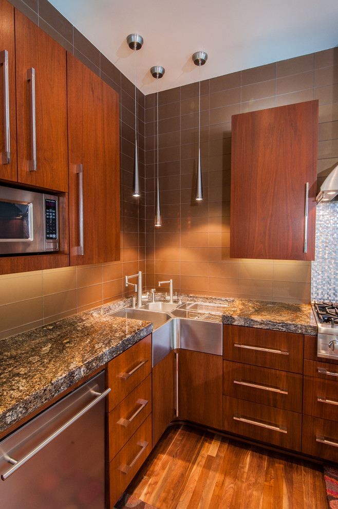 Example of a trendy galley eat-in kitchen design in Dallas with a farmhouse sink, flat-panel cabinets, medium tone wood cabinets, granite countertops, metallic backsplash, stainless steel appliances and glass tile backsplash