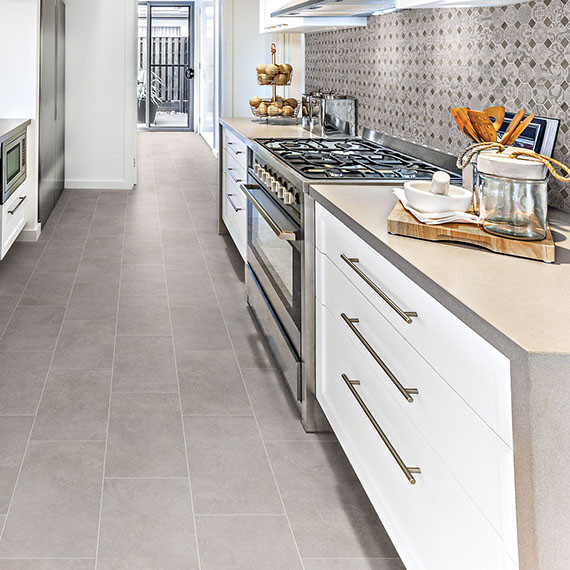 Inspiration for a medium sized contemporary galley enclosed kitchen in Orange County with a belfast sink, flat-panel cabinets, white cabinets, engineered stone countertops, multi-coloured splashback, stone tiled splashback, stainless steel appliances, porcelain flooring, no island, grey floors and grey worktops.