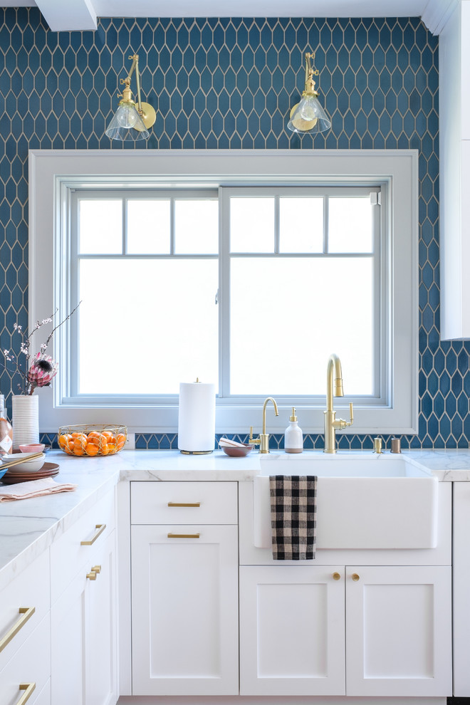 Imagen de cocina tradicional renovada con armarios estilo shaker, puertas de armario blancas, encimera de mármol, encimeras blancas, fregadero sobremueble y salpicadero azul