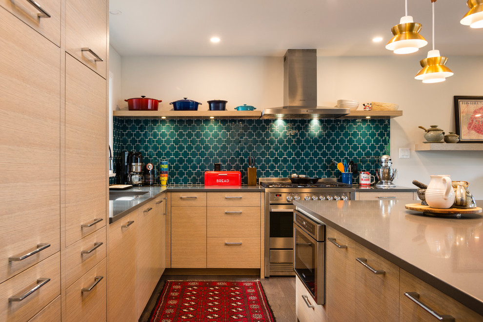 Bild på ett mellanstort funkis linjärt kök med öppen planlösning, med en undermonterad diskho, släta luckor, skåp i ljust trä, bänkskiva i kvarts, grönt stänkskydd, stänkskydd i glaskakel, rostfria vitvaror, mellanmörkt trägolv och en köksö