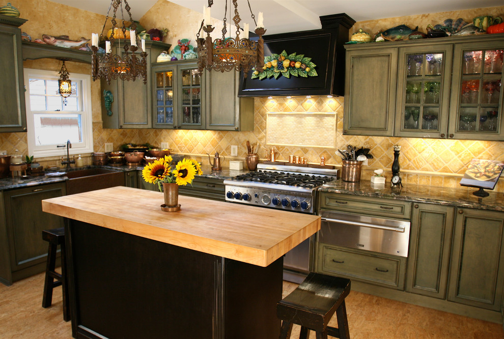 Inredning av ett klassiskt mellanstort kök, med en rustik diskho, luckor med infälld panel, gröna skåp, granitbänkskiva, beige stänkskydd, stänkskydd i stenkakel, rostfria vitvaror, korkgolv och en köksö