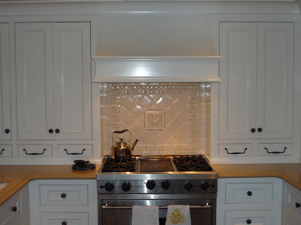 Exempel på ett mellanstort lantligt kök, med en undermonterad diskho, luckor med infälld panel, vita skåp, gult stänkskydd, rostfria vitvaror, mörkt trägolv och en halv köksö