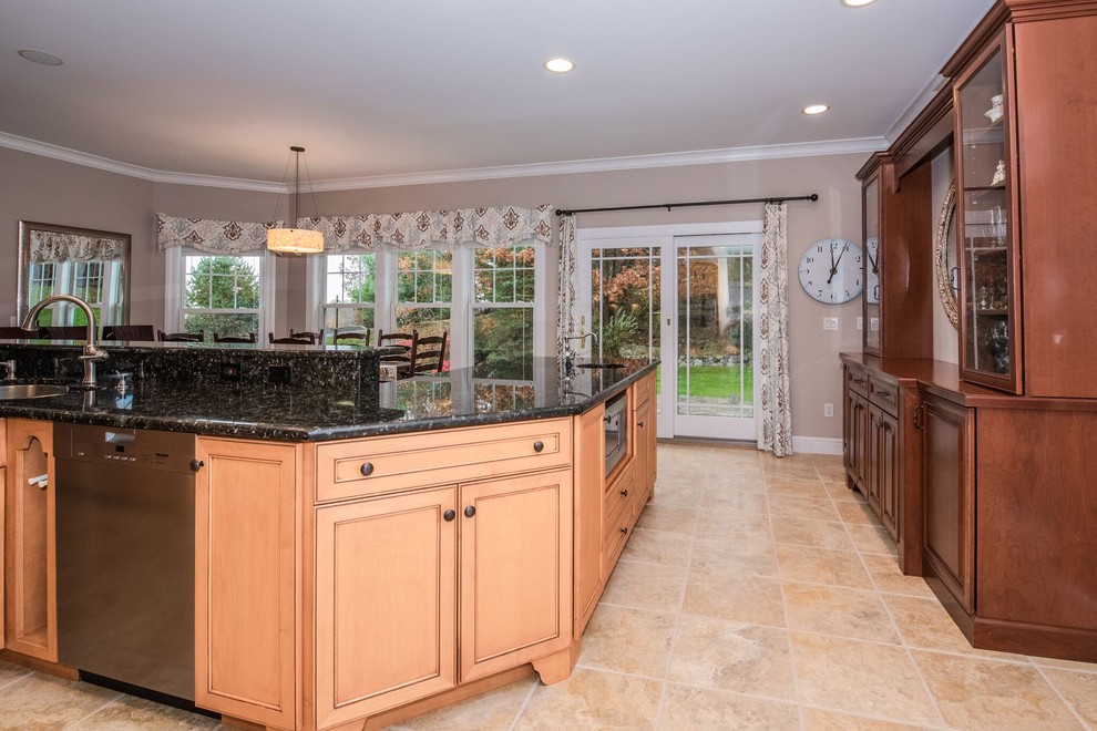Example of a large transitional single-wall limestone floor and beige floor eat-in kitchen design in New York with a drop-in sink, beaded inset cabinets, medium tone wood cabinets, laminate countertops, beige backsplash, stone tile backsplash, stainless steel appliances, an island and black countertops