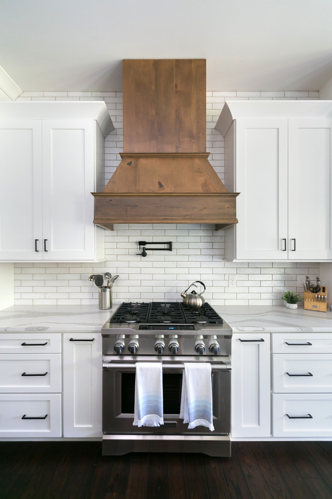 Foto på ett mycket stort lantligt vit kök med öppen planlösning, med en rustik diskho, skåp i shakerstil, vita skåp, bänkskiva i kvarts, vitt stänkskydd, stänkskydd i tegel, rostfria vitvaror och en köksö