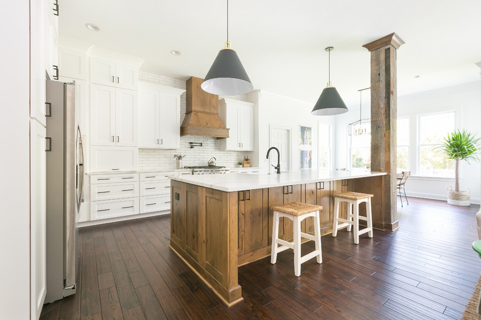 Foto de cocina campestre extra grande abierta con fregadero sobremueble, armarios estilo shaker, puertas de armario blancas, encimera de cuarzo compacto, salpicadero blanco, salpicadero de ladrillos, electrodomésticos de acero inoxidable, una isla y encimeras blancas