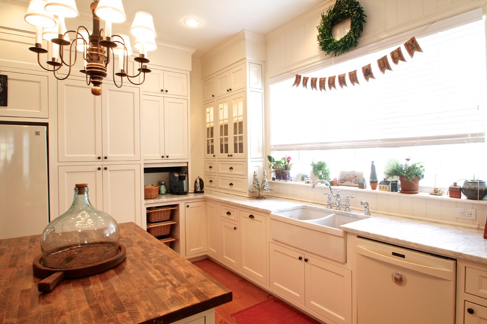 На фото: кухня в классическом стиле с фасадами в стиле шейкер, двойной мойкой, деревянной столешницей и белой техникой