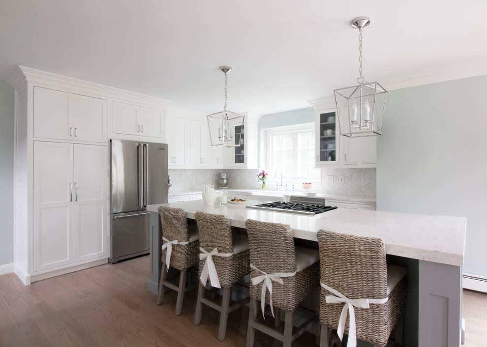 Mid-sized elegant l-shaped medium tone wood floor and brown floor eat-in kitchen photo in Boston with a farmhouse sink, beaded inset cabinets, white cabinets, quartz countertops, white backsplash, marble backsplash, stainless steel appliances and no island