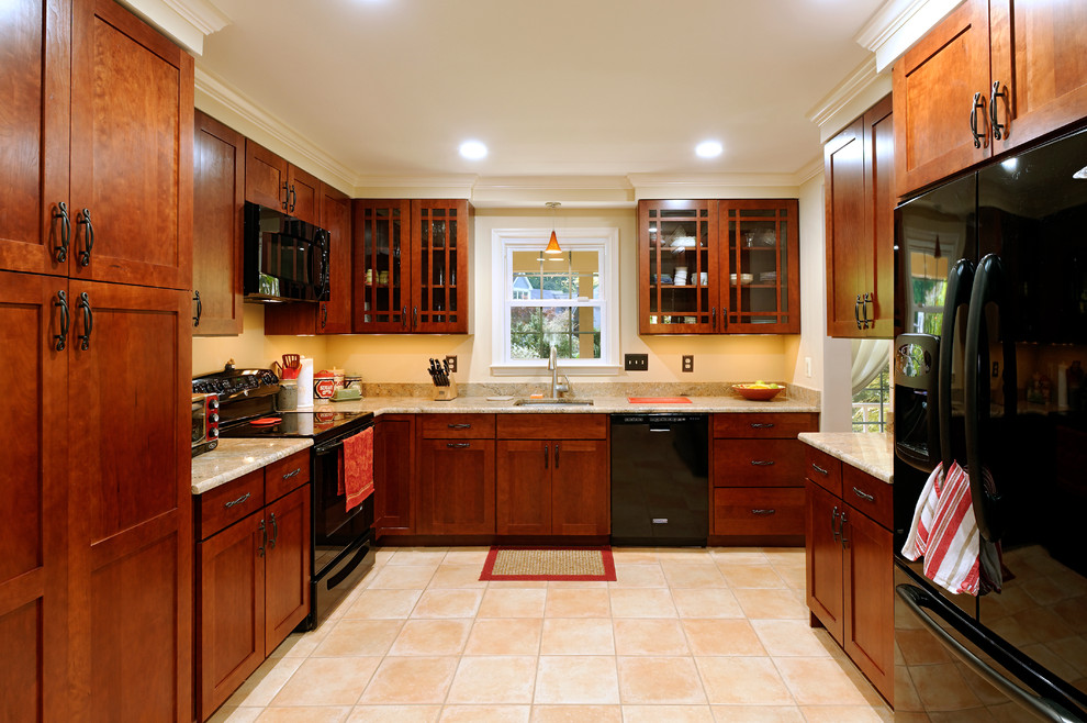 Elegant l-shaped enclosed kitchen photo in DC Metro with a single-bowl sink, dark wood cabinets and black appliances
