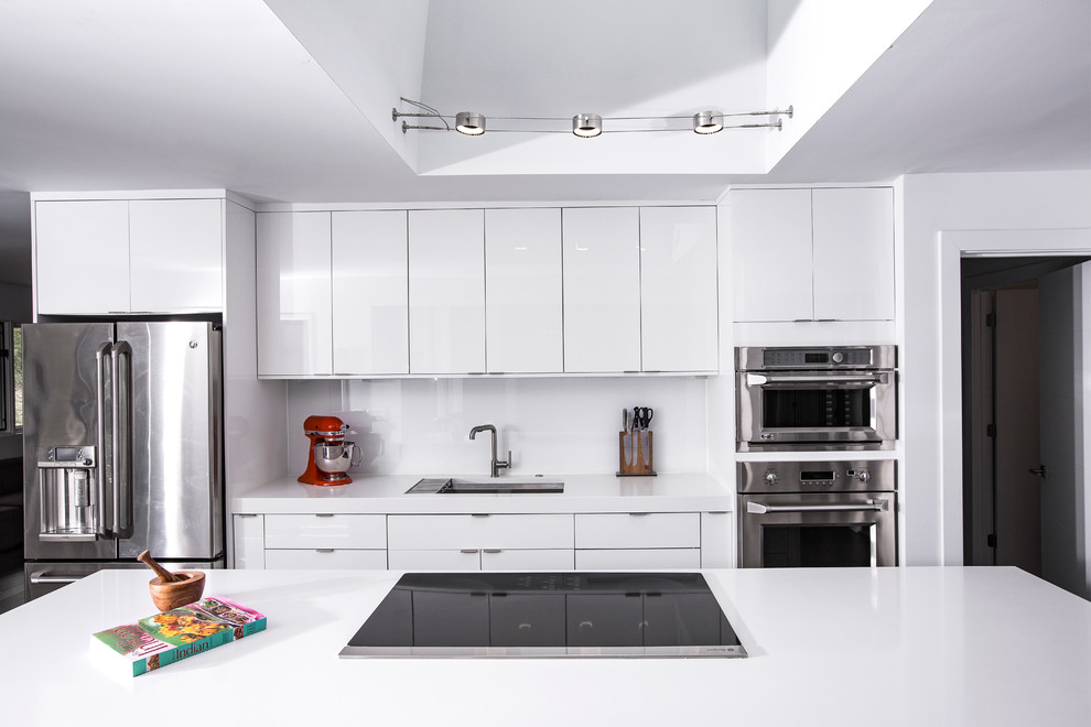 Inredning av ett modernt mellanstort vit linjärt vitt kök, med släta luckor, vita skåp, bänkskiva i koppar, vitt stänkskydd, rostfria vitvaror, en köksö, en undermonterad diskho, mörkt trägolv och brunt golv