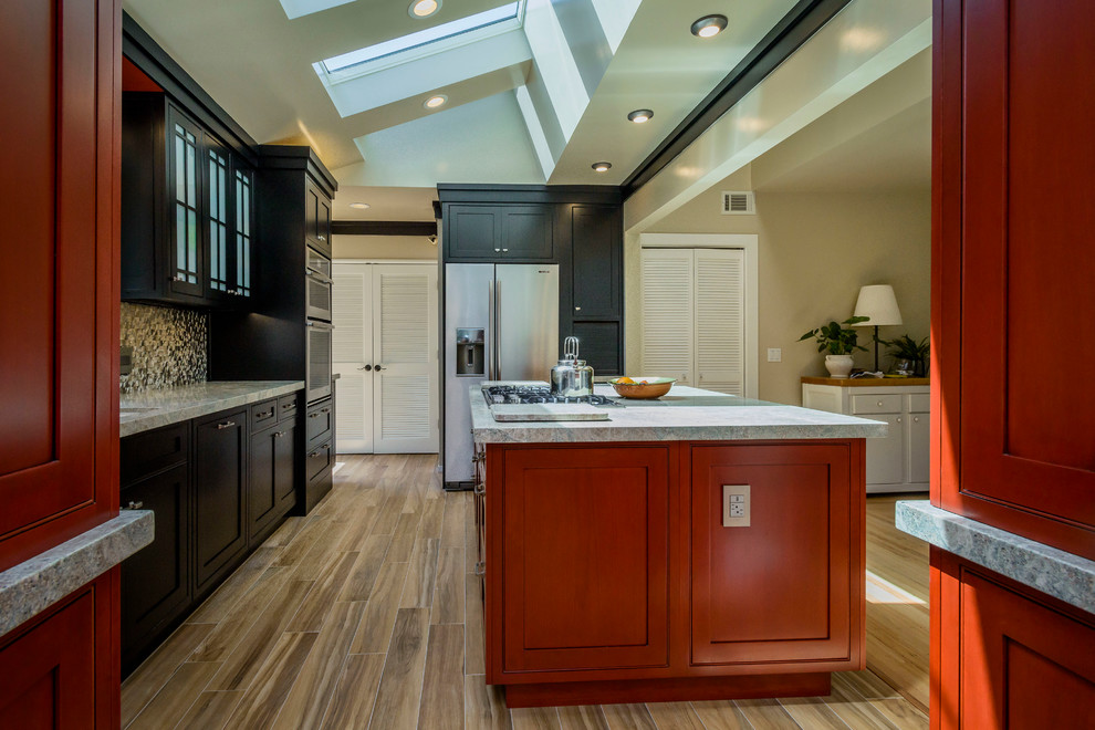 Example of a mid-sized eclectic u-shaped porcelain tile eat-in kitchen design in Other with an undermount sink, beaded inset cabinets, black cabinets, granite countertops, metallic backsplash, metal backsplash, stainless steel appliances and an island