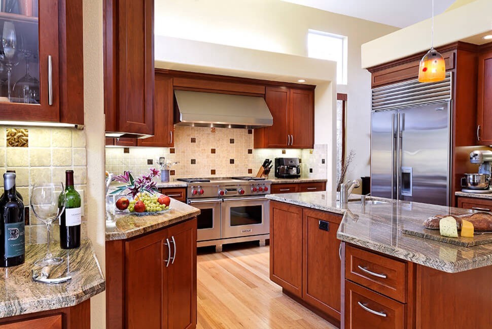 Example of a large transitional l-shaped light wood floor eat-in kitchen design in San Francisco with an undermount sink, recessed-panel cabinets, medium tone wood cabinets, granite countertops, beige backsplash, stainless steel appliances, an island, porcelain backsplash and multicolored countertops