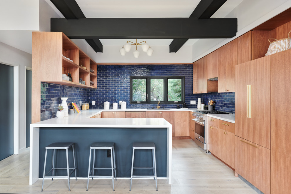 1960s u-shaped light wood floor and beige floor kitchen photo in San Francisco with an undermount sink, flat-panel cabinets, medium tone wood cabinets, blue backsplash, stainless steel appliances, a peninsula and white countertops