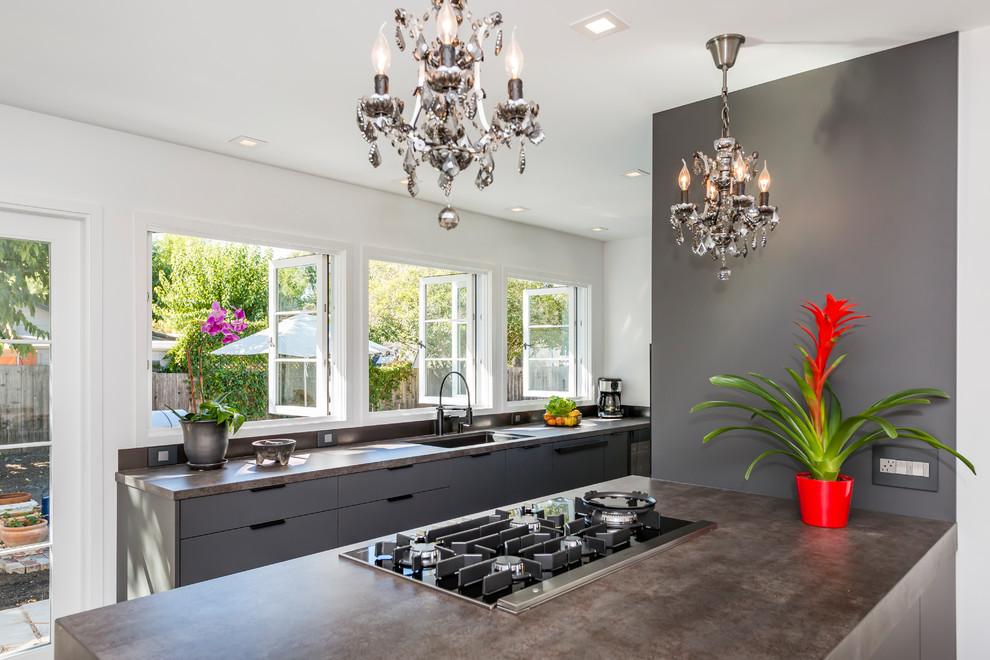 Immagine di una cucina moderna di medie dimensioni con lavello sottopiano, ante lisce, ante nere, top in quarzo composito, paraspruzzi nero, paraspruzzi con piastrelle di metallo, elettrodomestici neri e pavimento nero