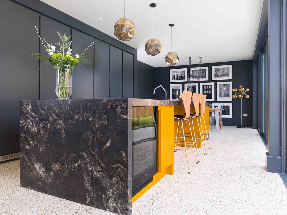 エセックスにある中くらいなコンテンポラリースタイルのおしゃれなアイランドキッチン (フラットパネル扉のキャビネット、黒いキャビネット、大理石カウンター、テラゾーの床、白い床) の写真
