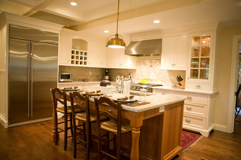 Exempel på ett avskilt, mellanstort klassiskt l-kök, med en undermonterad diskho, luckor med infälld panel, vita skåp, granitbänkskiva, flerfärgad stänkskydd, stänkskydd i mosaik, rostfria vitvaror, mellanmörkt trägolv och en köksö