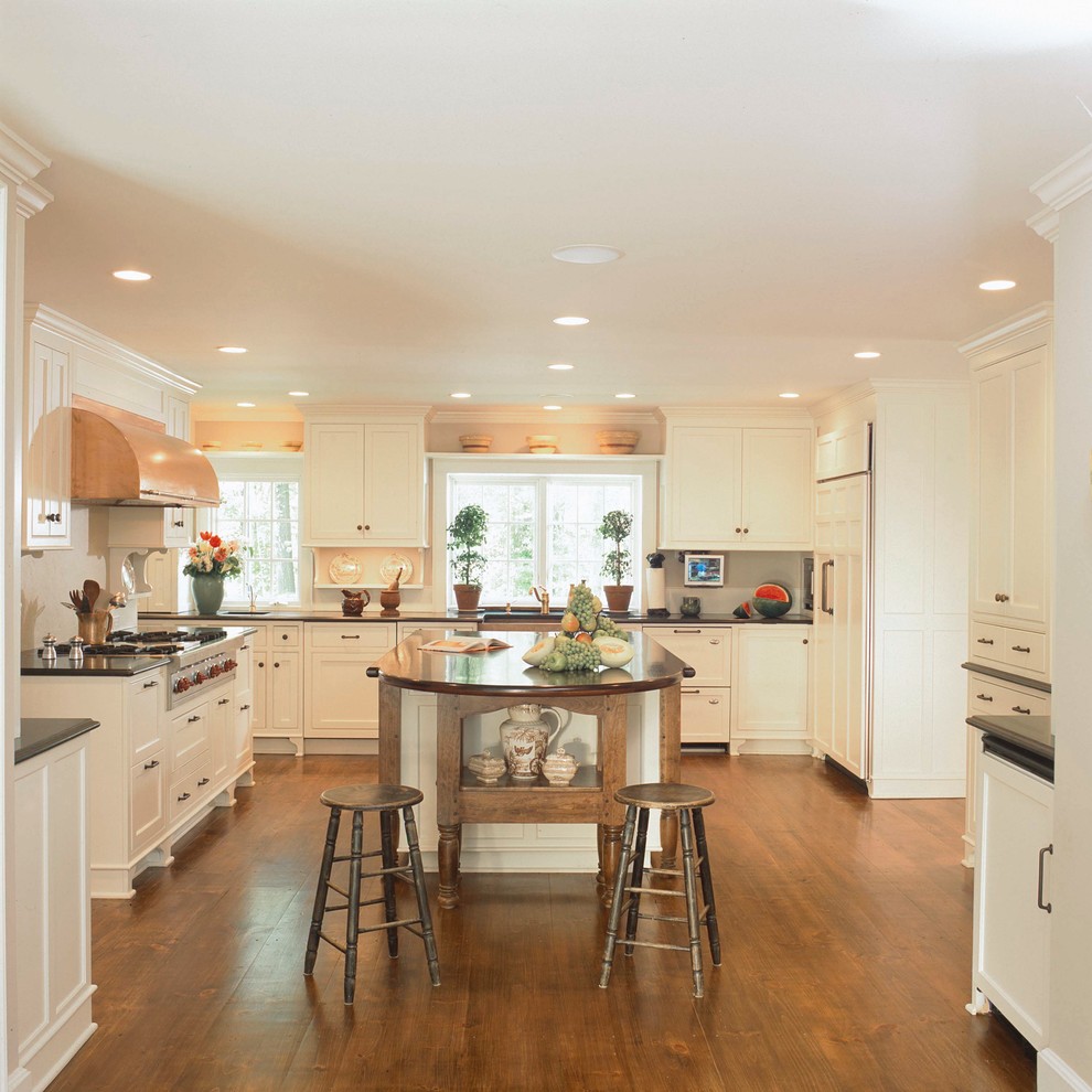 Example of a classic u-shaped kitchen design in New York with shaker cabinets, white cabinets and paneled appliances
