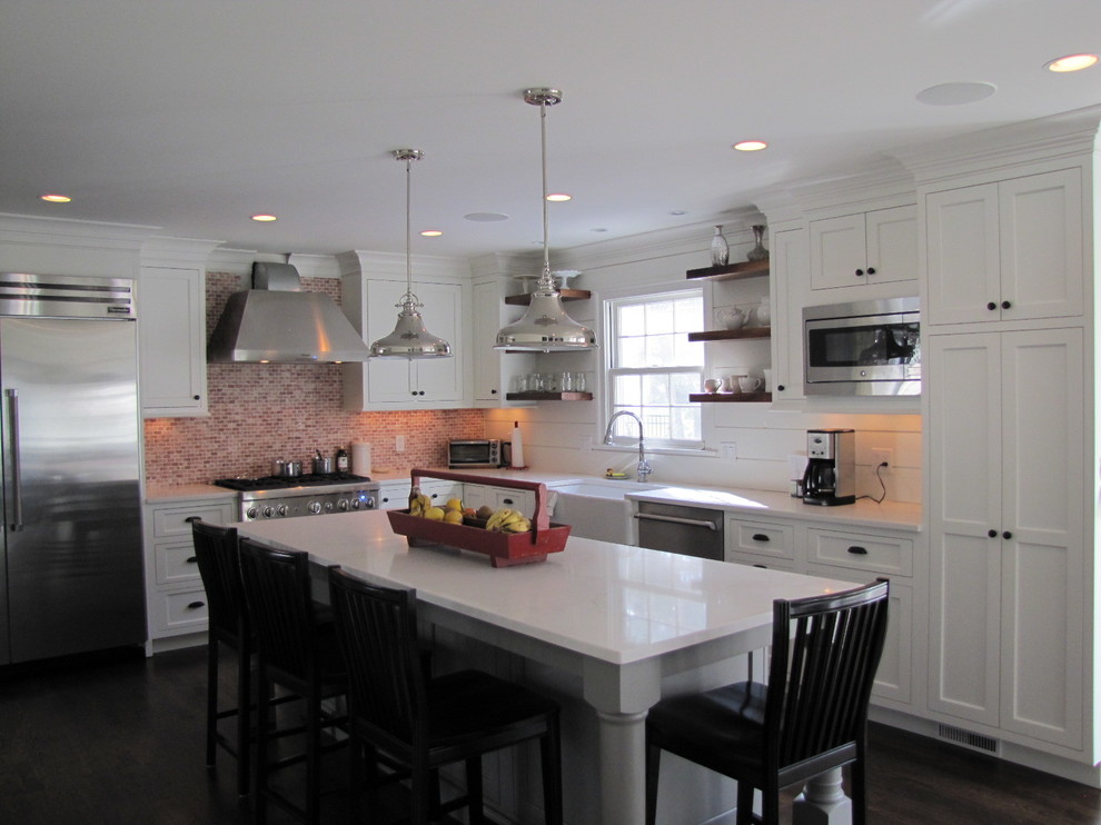 Foto på ett stort lantligt l-kök, med en rustik diskho, skåp i shakerstil, vita skåp, bänkskiva i kvarts, rött stänkskydd, stänkskydd i keramik, rostfria vitvaror, mörkt trägolv och en köksö