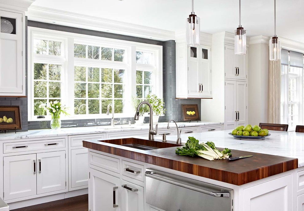 Kitchen - traditional kitchen idea in New York with an undermount sink, beaded inset cabinets, white cabinets, wood countertops, gray backsplash, subway tile backsplash, stainless steel appliances and an island