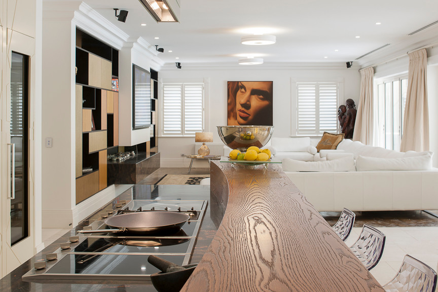 メルボルンにあるラグジュアリーな巨大なコンテンポラリースタイルのおしゃれなキッチン (中間色木目調キャビネット、木材カウンター、黒い調理設備、ライムストーンの床) の写真
