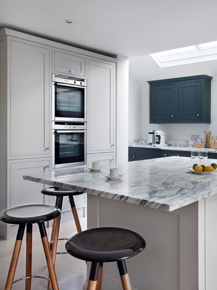 Foto på ett mellanstort funkis kök och matrum, med en integrerad diskho, skåp i shakerstil, grå skåp, marmorbänkskiva, grått stänkskydd, stänkskydd i sten, rostfria vitvaror, klinkergolv i terrakotta och en köksö