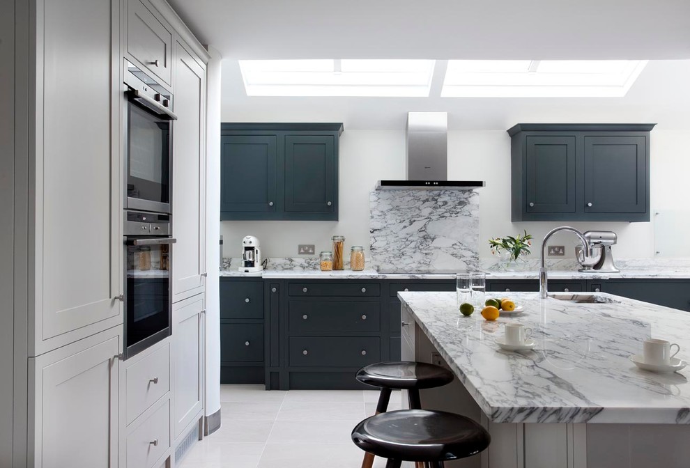 Example of a mid-sized trendy terra-cotta tile eat-in kitchen design in Dublin with an integrated sink, shaker cabinets, gray cabinets, marble countertops, gray backsplash, stone slab backsplash, stainless steel appliances and an island
