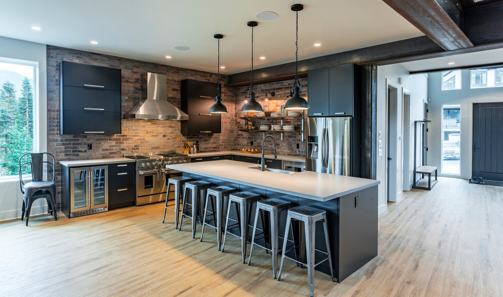 Large minimalist l-shaped vinyl floor and brown floor open concept kitchen photo in Vancouver with an undermount sink, flat-panel cabinets, black cabinets, quartz countertops, red backsplash, brick backsplash, stainless steel appliances, an island and white countertops