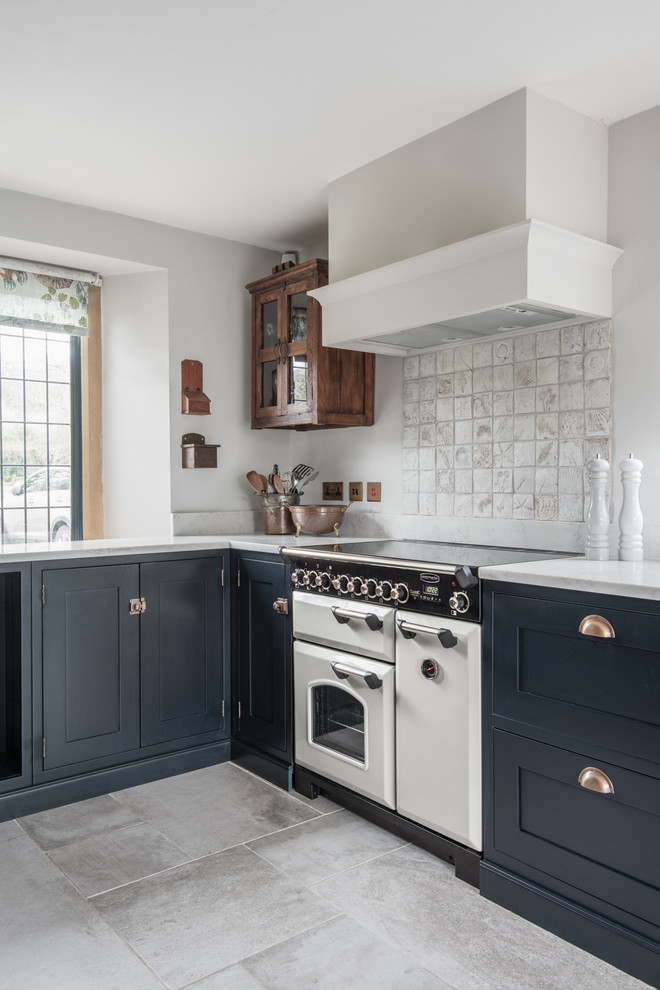 Mid-sized transitional u-shaped limestone floor eat-in kitchen photo in Devon with a farmhouse sink, shaker cabinets, blue cabinets, solid surface countertops, no island and white countertops