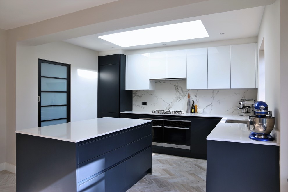 This is an example of a contemporary kitchen in Hertfordshire with flat-panel cabinets, blue cabinets, quartz worktops, white splashback, marble splashback and an island.